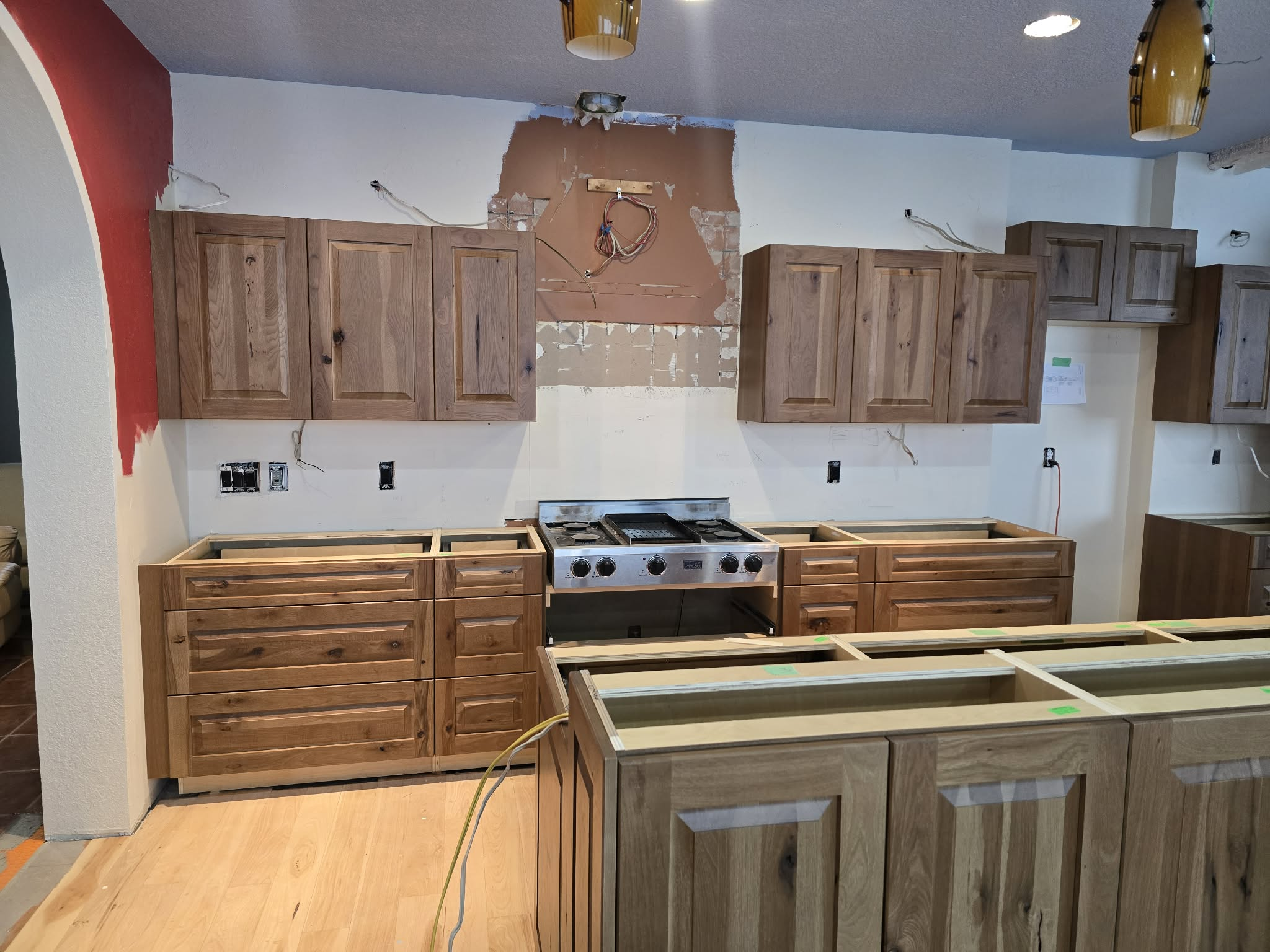 Kitchen cabinetry installation with natural wood finishes and island detail