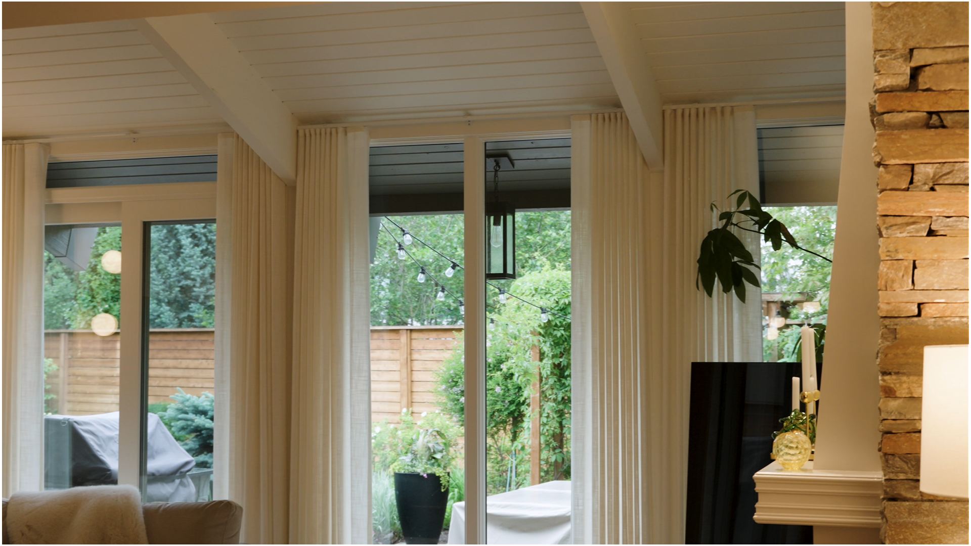 Fresh white-painted ceiling and trim beside a natural stone fireplace wall