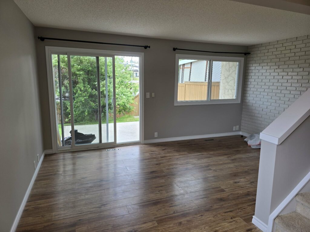 Living room with the replacement balcony door, window, painted walls and refinished frames