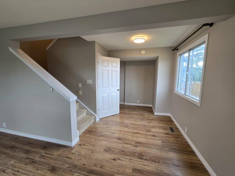 Open living and dining area with refreshed walls, trim and window frames