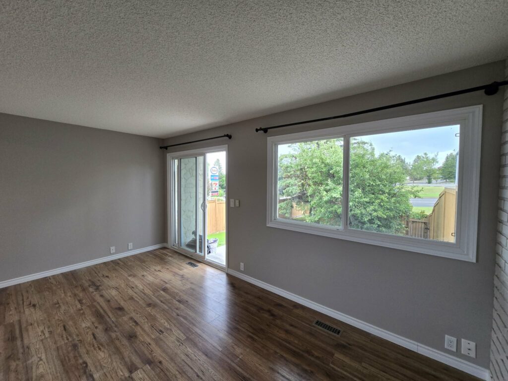 Wide living-room view with the completed window and balcony-door openings