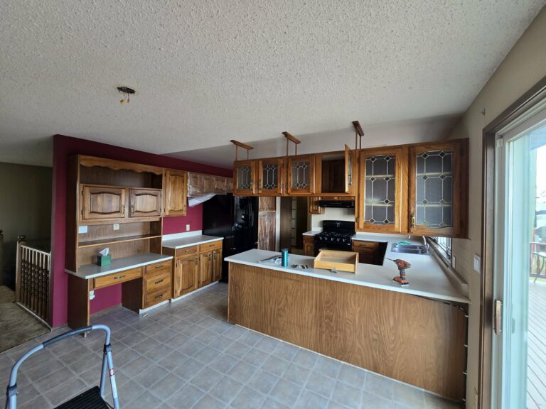 Wide kitchen view during early renovation work with original patterned flooring and protected work areas