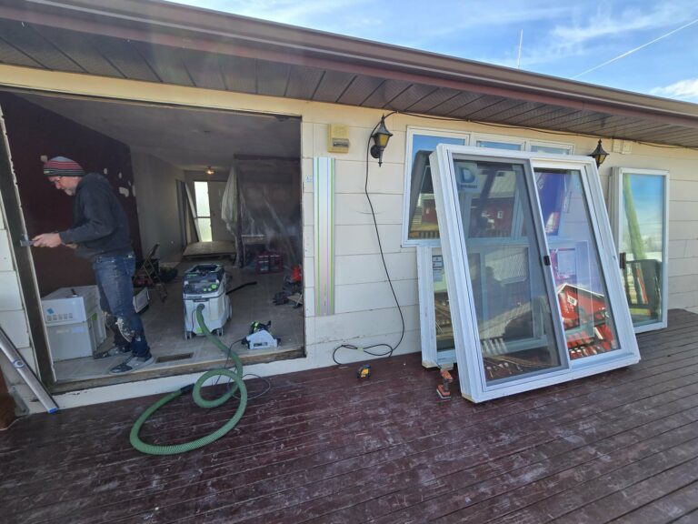 Window and balcony-door replacement work underway with tools and replacement units visible