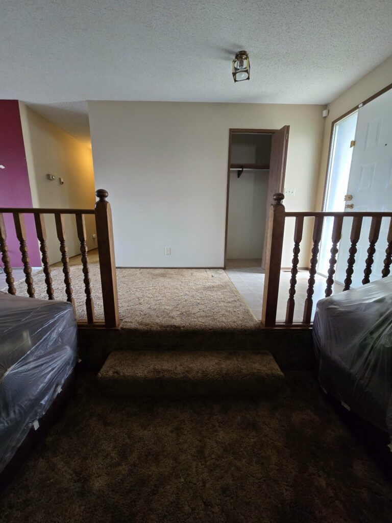 Entry landing and carpeted steps with furniture protected during renovation