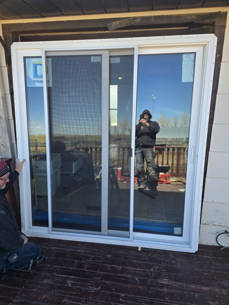 Replacement balcony door being positioned in the prepared opening