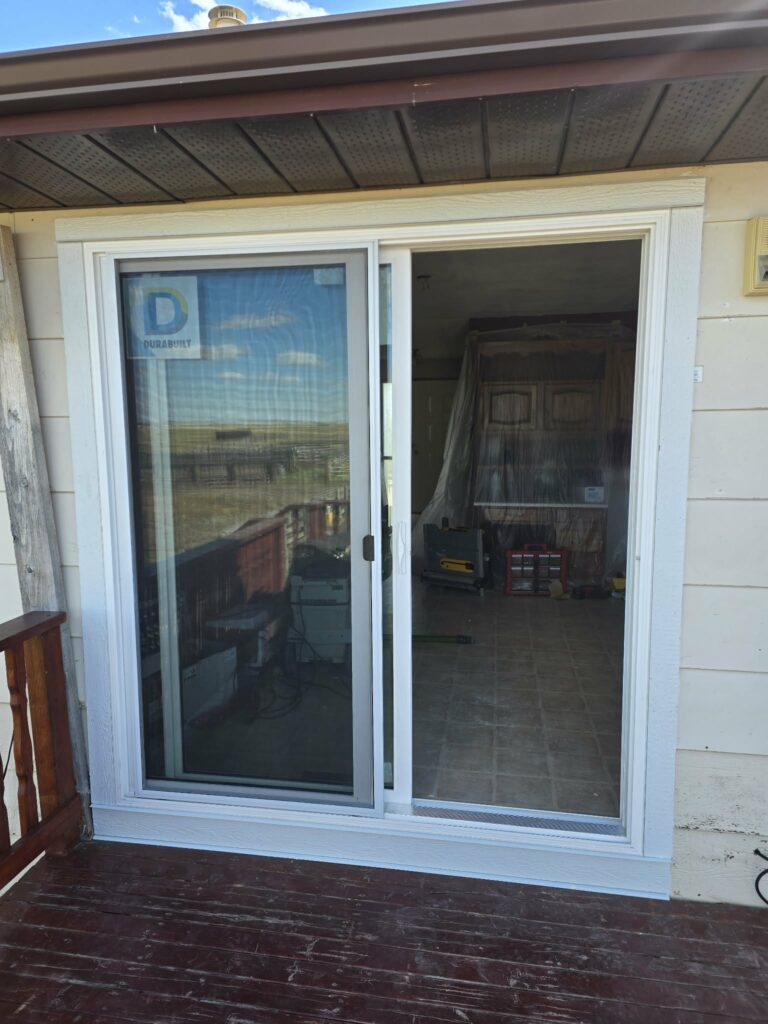 Replacement balcony door with exterior trim returned and work details still visible