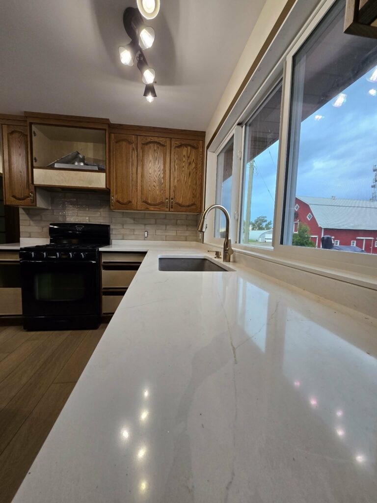 Kitchen countertop, sink wall and existing wood cabinetry during late-stage work