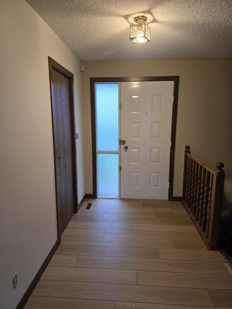 Front entry with light flooring, painted walls, dark trim and renovation details in progress