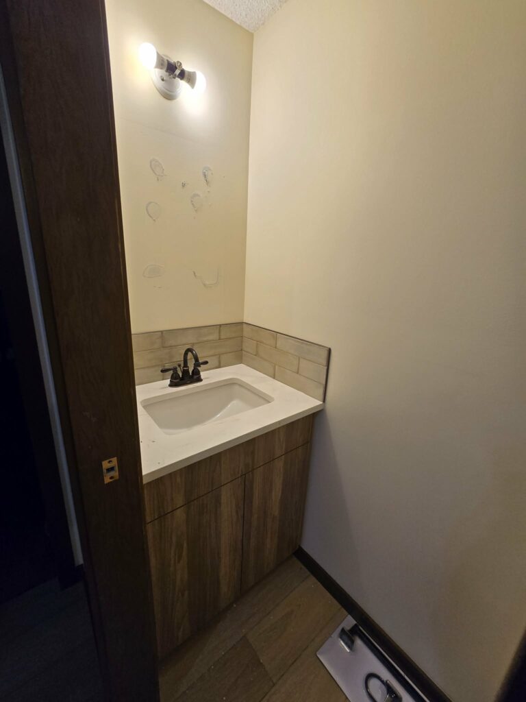 Closer view of the powder-room countertop, sink and backsplash during installation