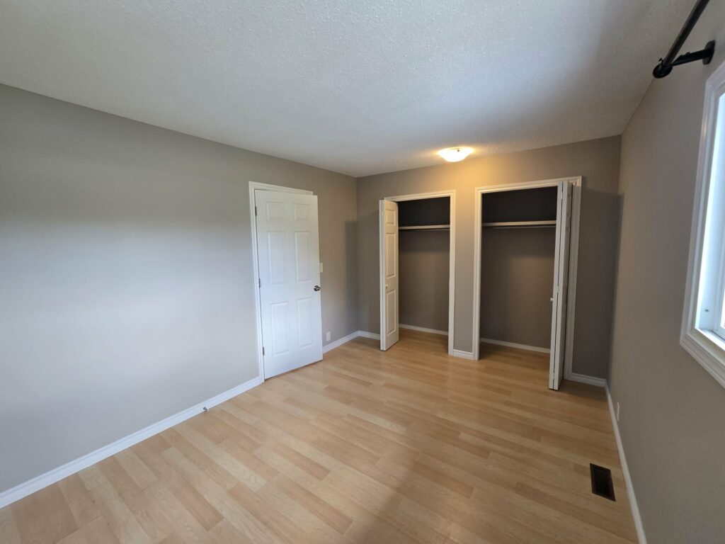 Finished bedroom with refreshed walls, trim and closet doors
