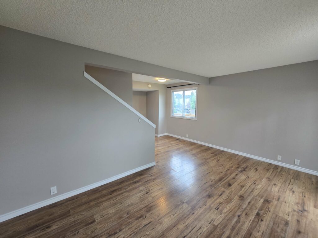 Wide living-room view with refreshed walls, trim and window frame