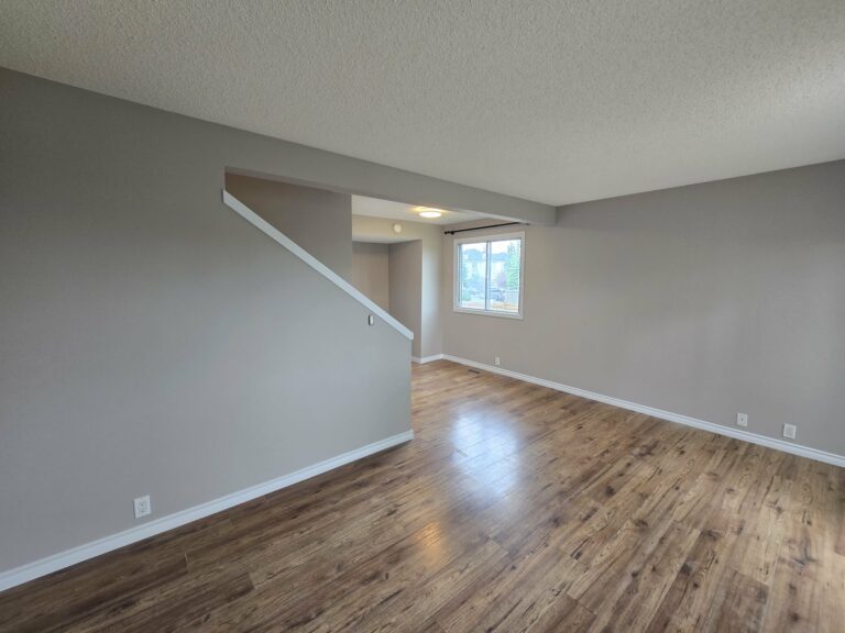 Wide living-room view with refreshed walls, trim and window frame